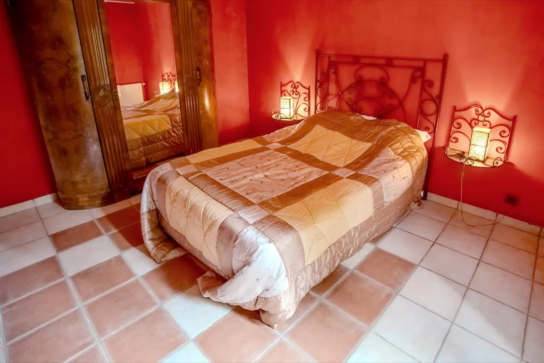 Chambre provençale d'un gîte du domaine, murs chauds et sol en tomettes