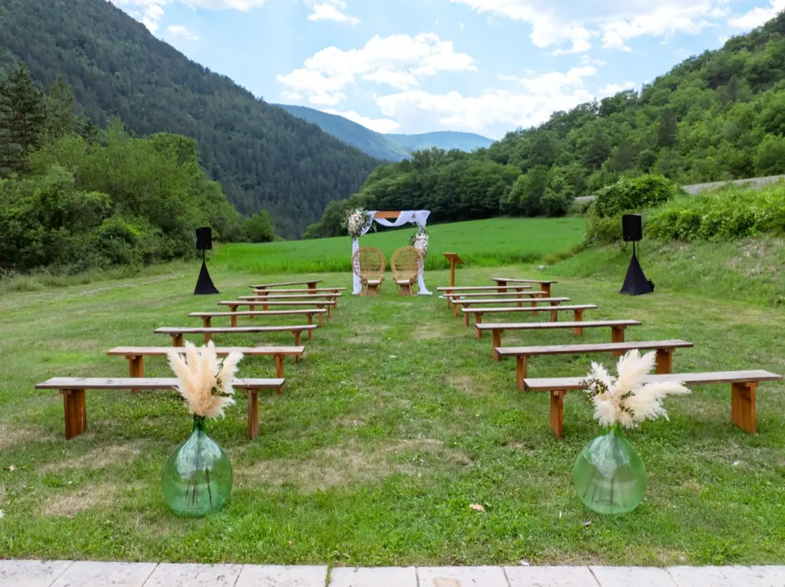 Allée de bancs en bois et pampas menant à l'arche de cérémonie
