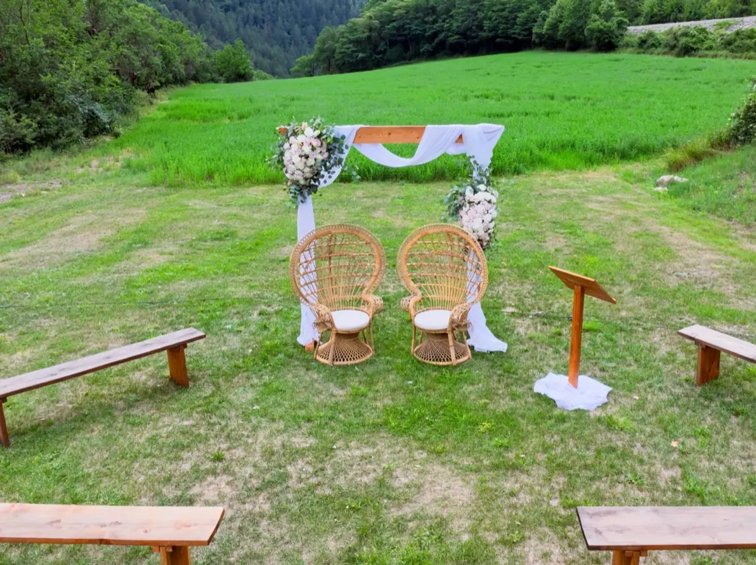 Arche de cérémonie et fauteuils en rotin dans le parc du domaine