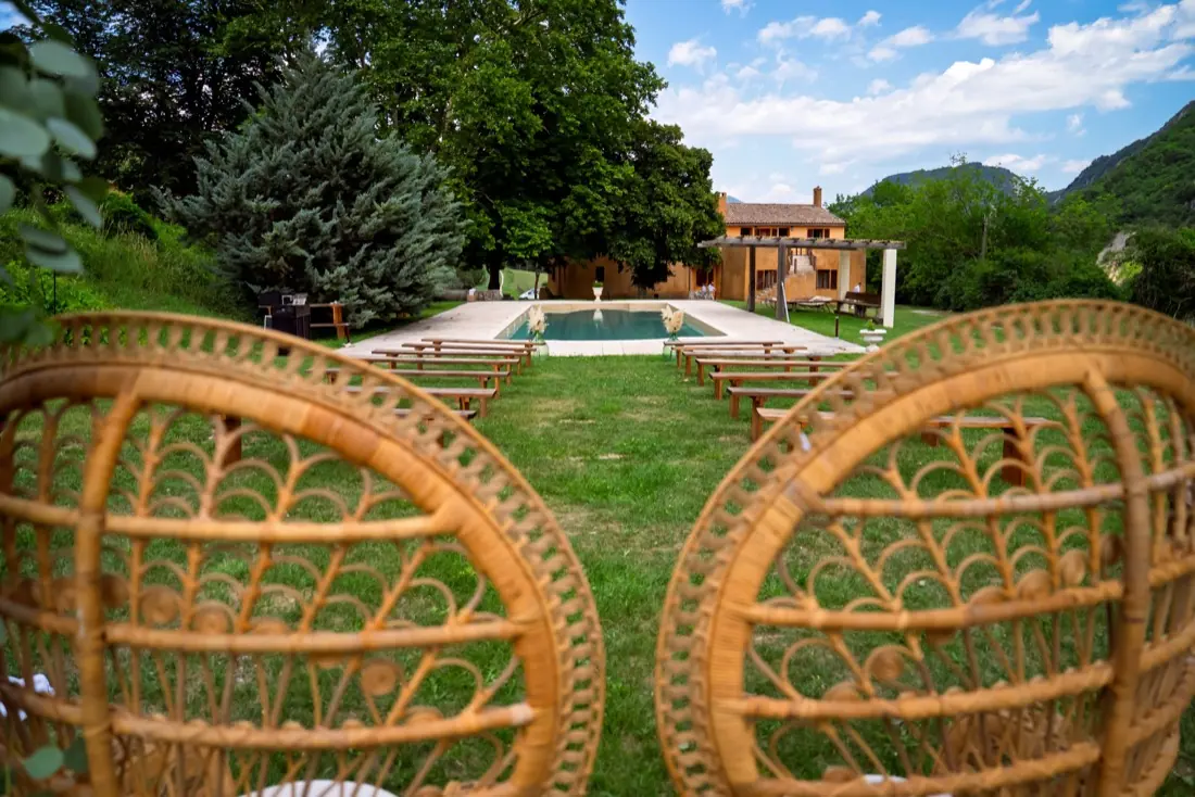 Espace cérémonie face au mas et à la piscine, fauteuils en rotin