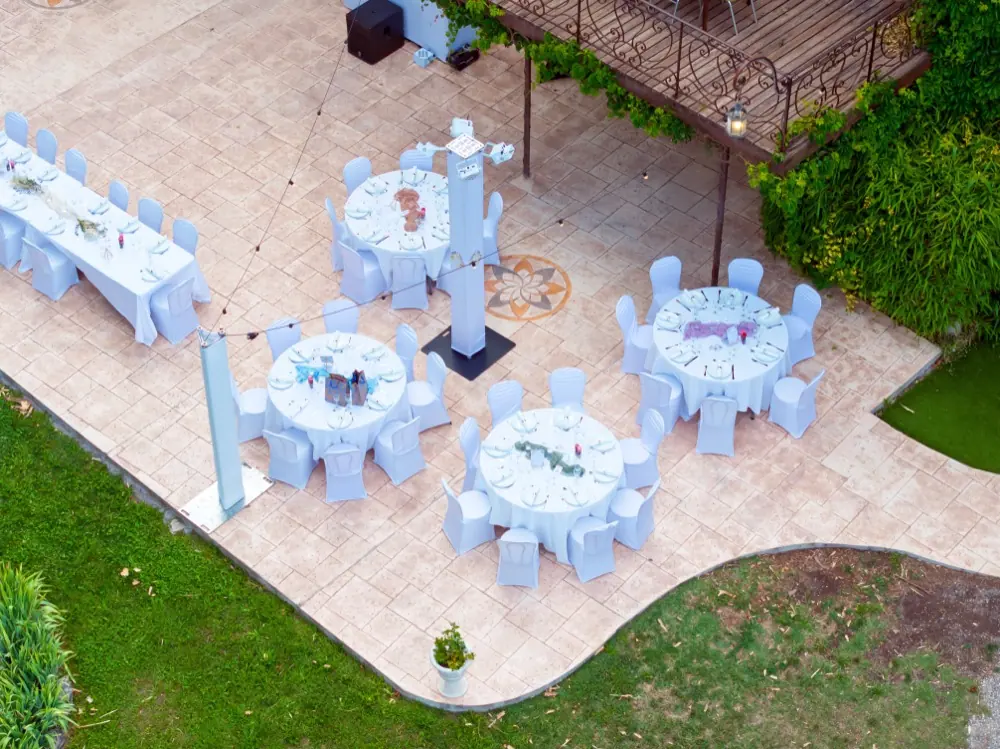 Terrasse dressée de tables rondes pour une réception professionnelle au Domaine des Sources